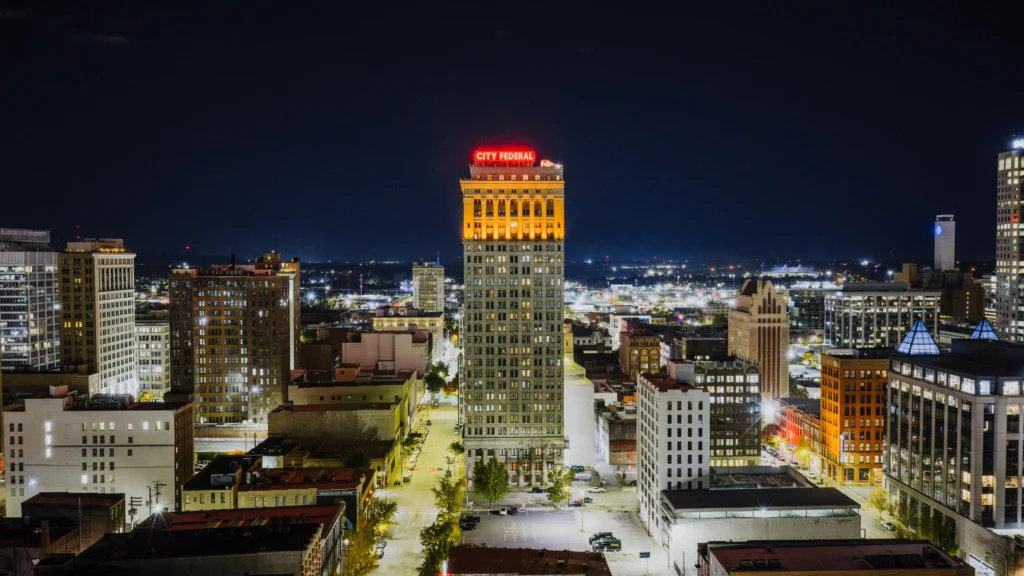 picture of a nighttime city skyline featuring the illuminated city federal building in the center