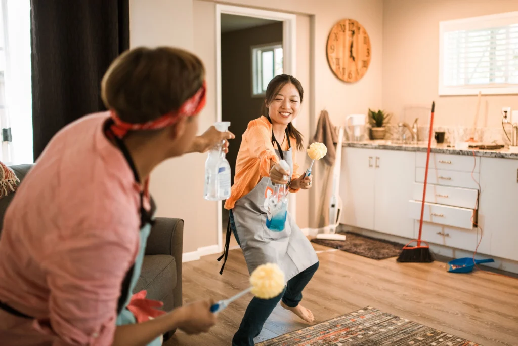 Picture of a couple playfully cleaning a living room