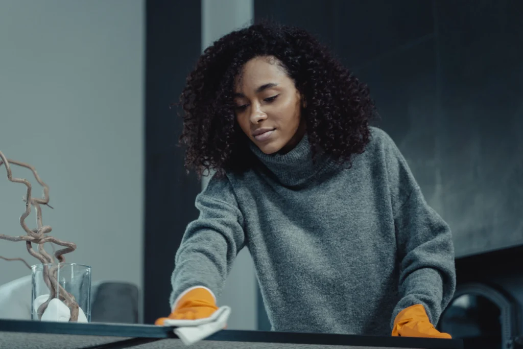 Picture of a woman in orange gloves wiping a counter