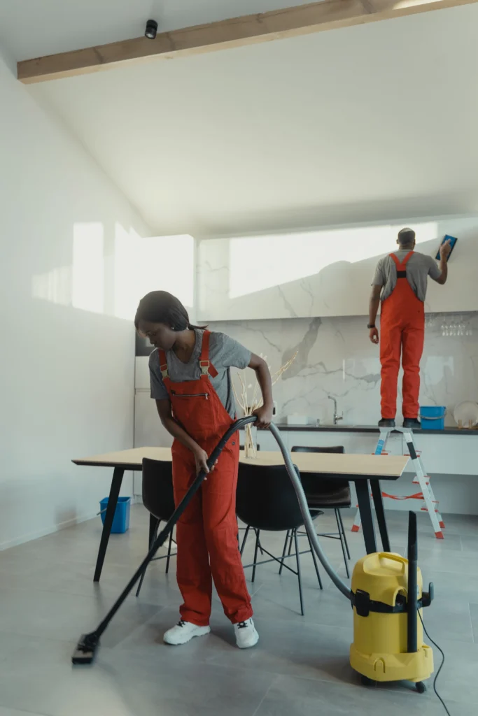 Picture of a team in red overalls cleaning a modern kitchen